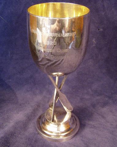 Trophy Cup atop three crossed Cricket Bats